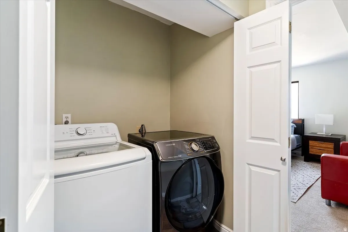 Laundry area with carpet and washing machine and dryer