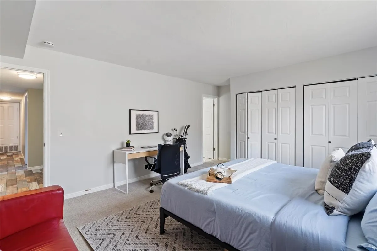 Primary Bedroom with a desk, two closets, and light colored carpet