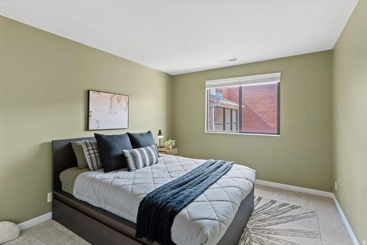 Bedroom featuring light carpet and baseboards