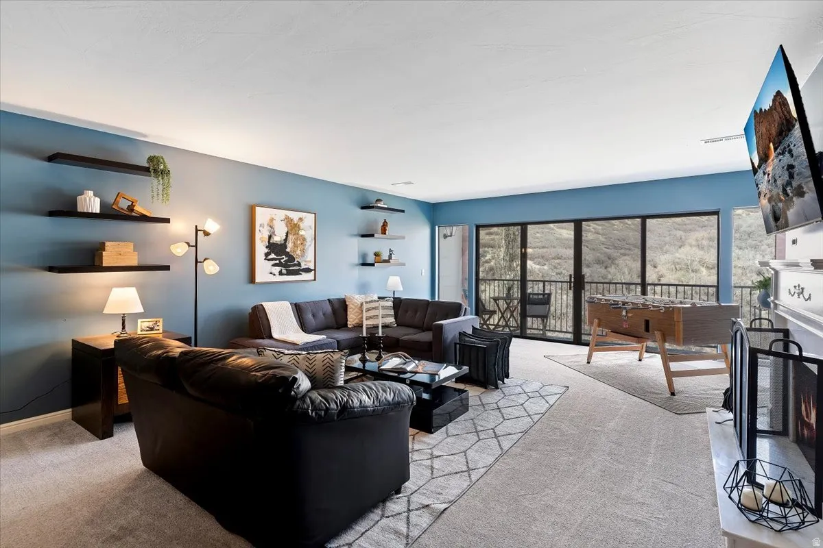 Living room featuring a warm lit fireplace and light colored carpet