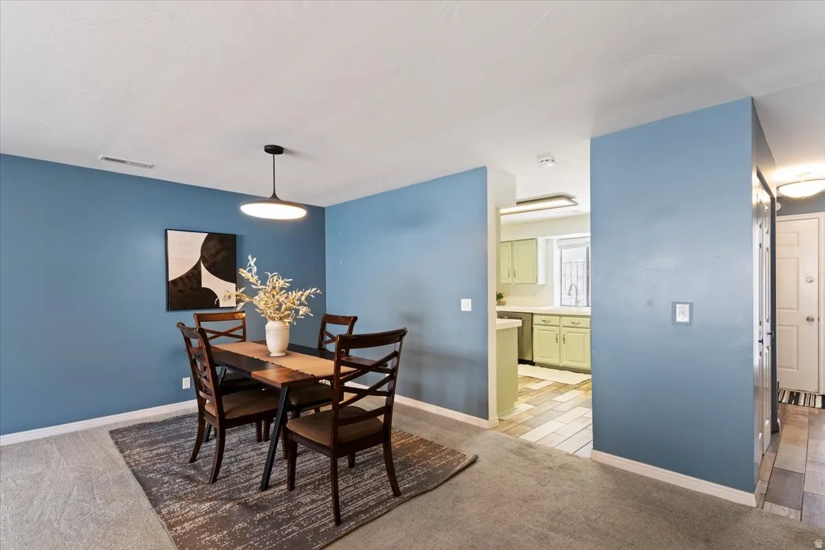 Dining room featuring light colored carpet and baseboards