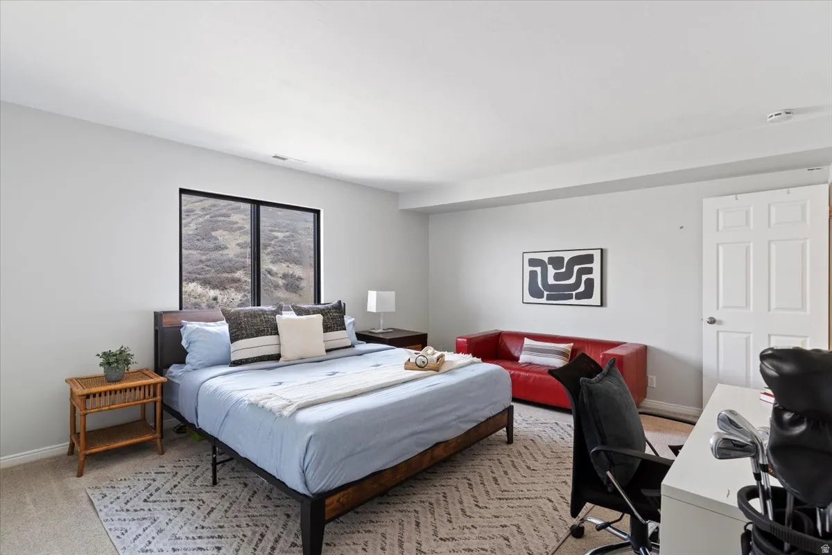 Bedroom with a desk and light colored carpet