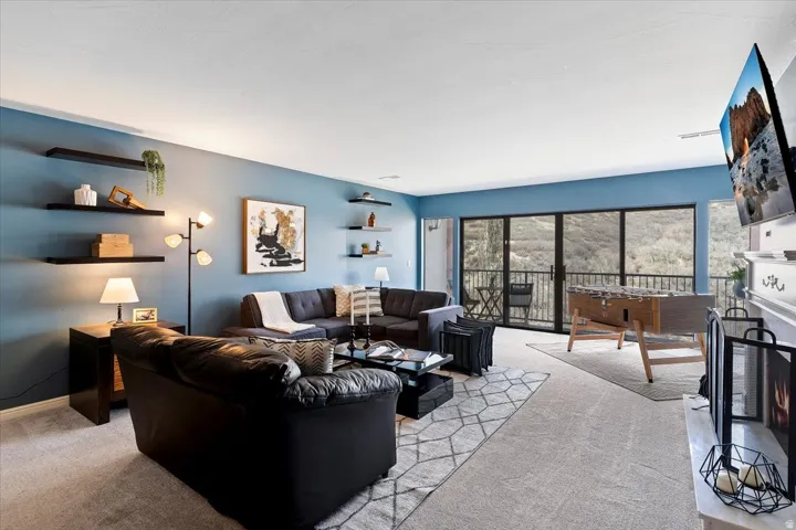 Living room featuring a warm lit fireplace and light colored carpet