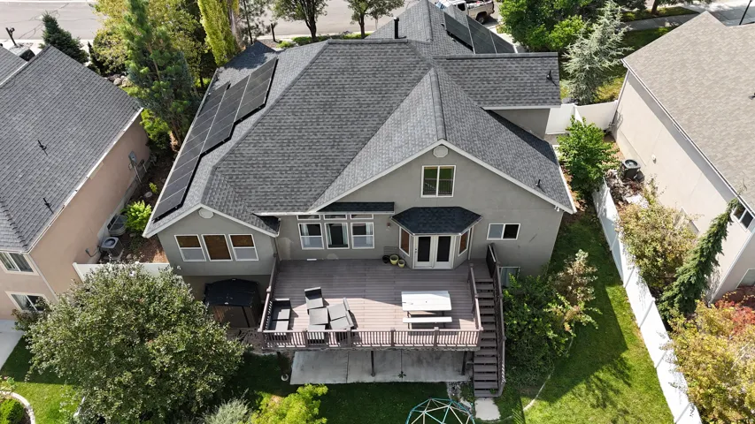 Roof-mounted solar panels, multi-level composite deck, bay window, and a spacious green lawn