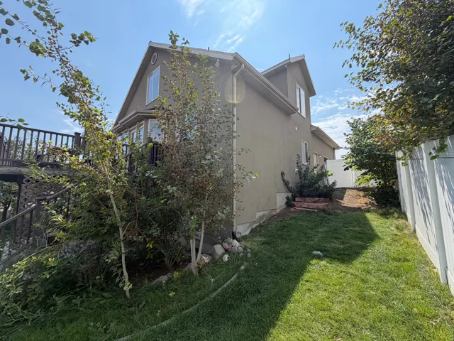 Stucco exterior with a multi-level deck, bay window, and gabled roofline