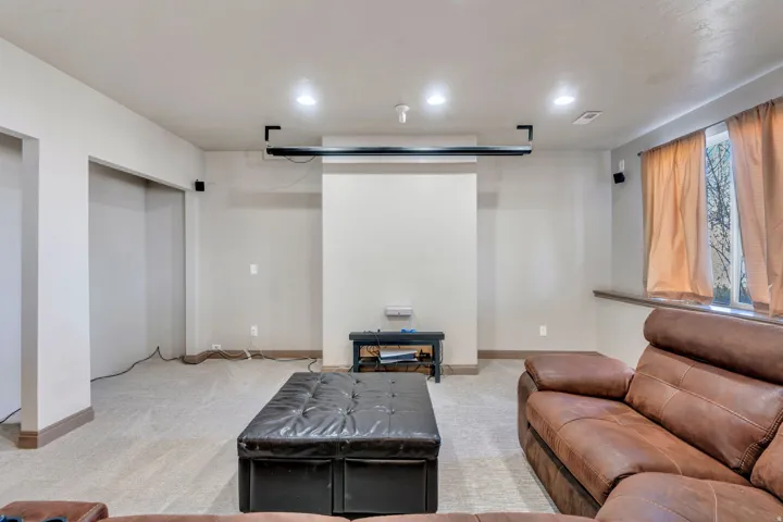 Living area with light carpet and recessed lighting