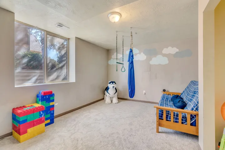 Recreation room with carpet flooring and a textured ceiling