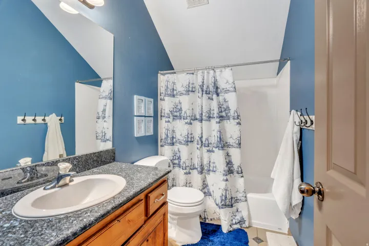 Full bathroom with vanity, shower / tub combo with curtain, and light tile patterned flooring