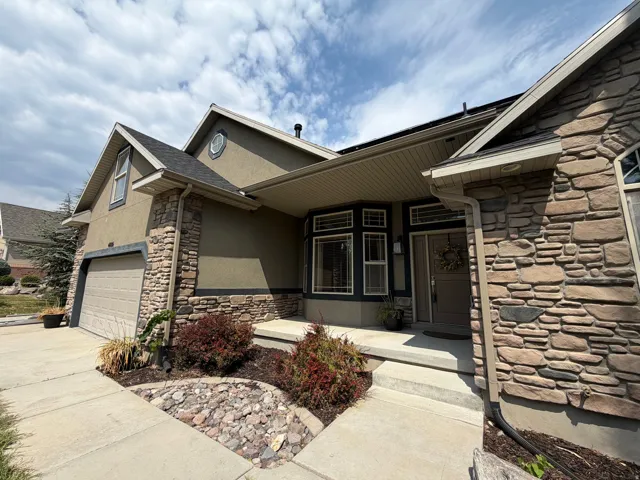 Stucco and stone exterior with an attached garage