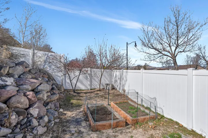 Fenced backyard featuring a garden