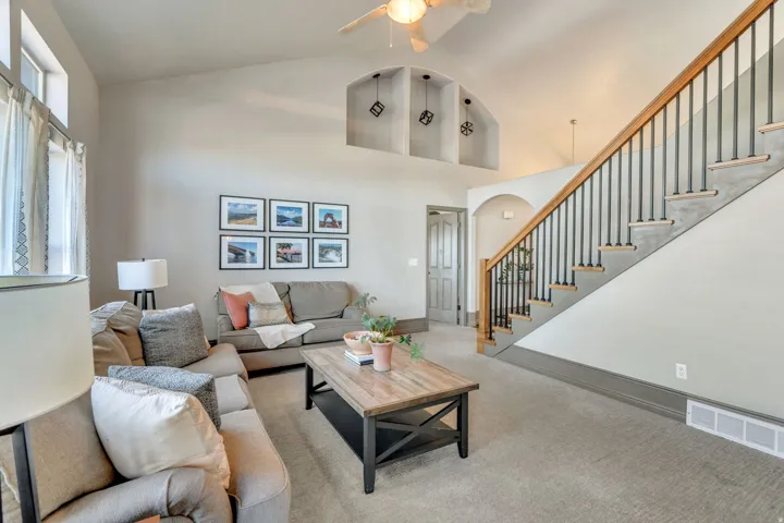 Main living room, entrance to primary suite, and stairs to second floor