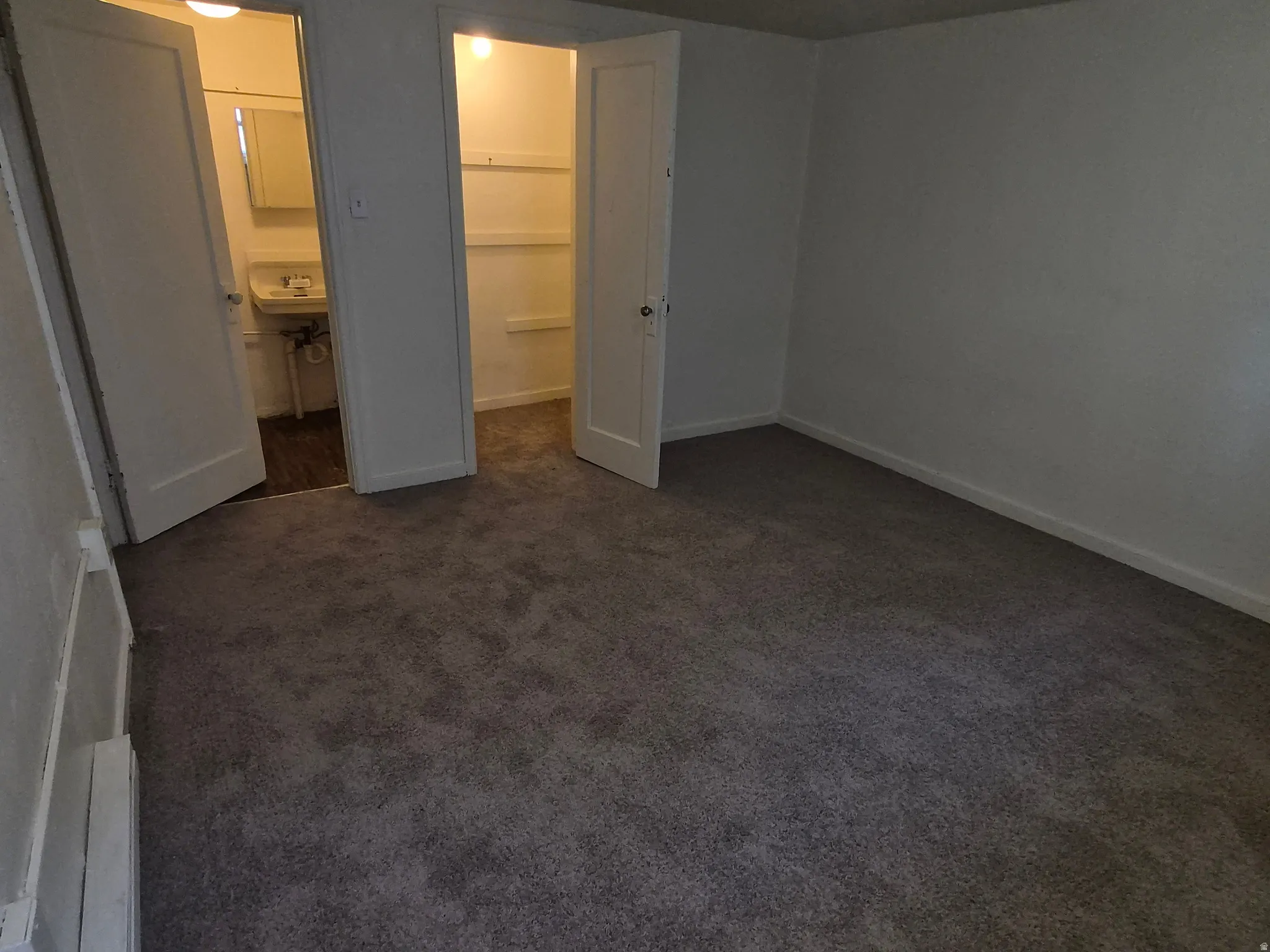 Unfurnished bedroom featuring dark colored carpet and a spacious closet