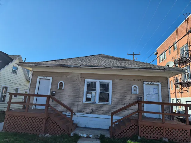 View of front of house featuring a deck and a shingled roof