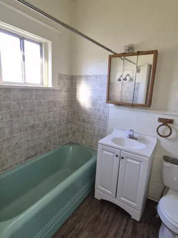 Bathroom with vanity, dark wood finished floors, and tub / shower combination