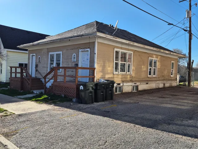 Back of property featuring a deck and roof with shingles