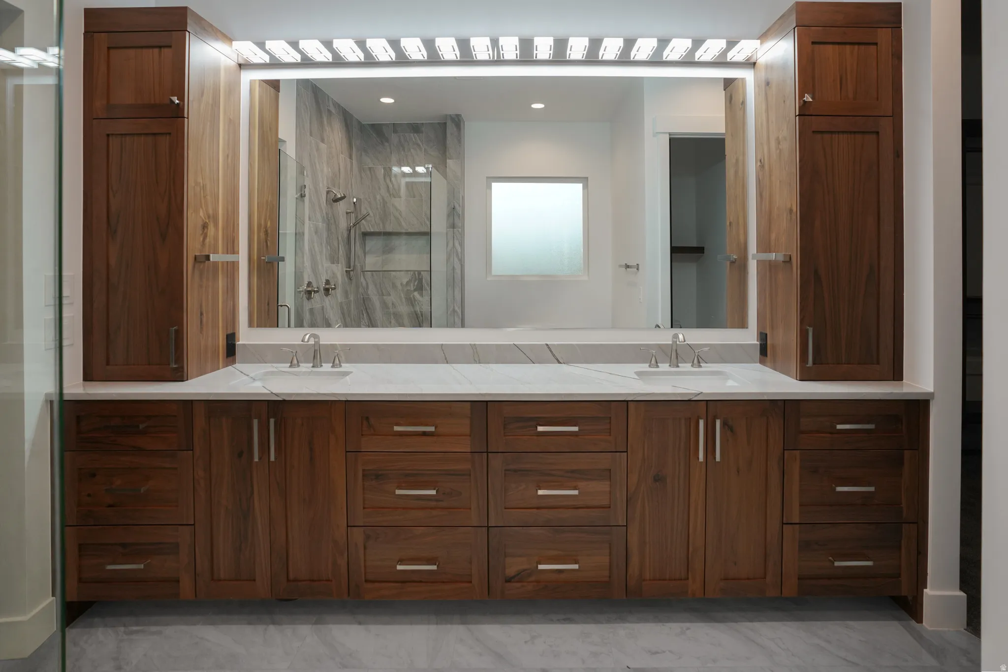 Full bathroom featuring double vanity and a shower stall