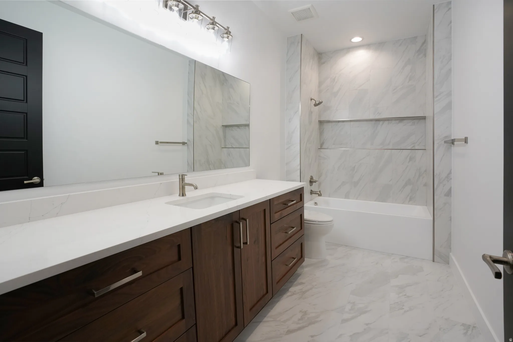 Full bathroom with vanity, bathing tub / shower combination, and light marble finish flooring