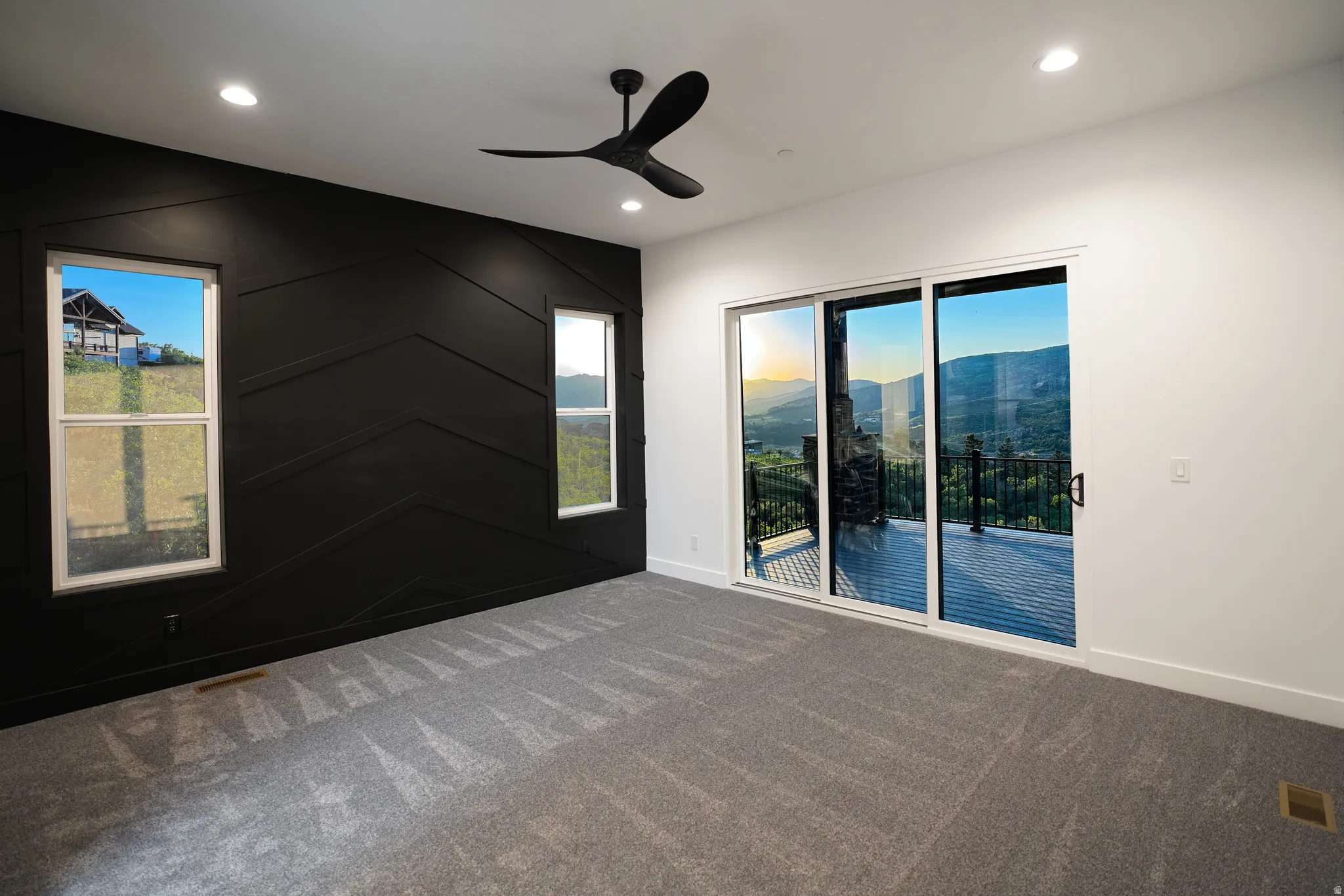 Unfurnished room featuring ceiling fan, a mountain view, dark colored carpet, healthy amount of natural light, and recessed lighting