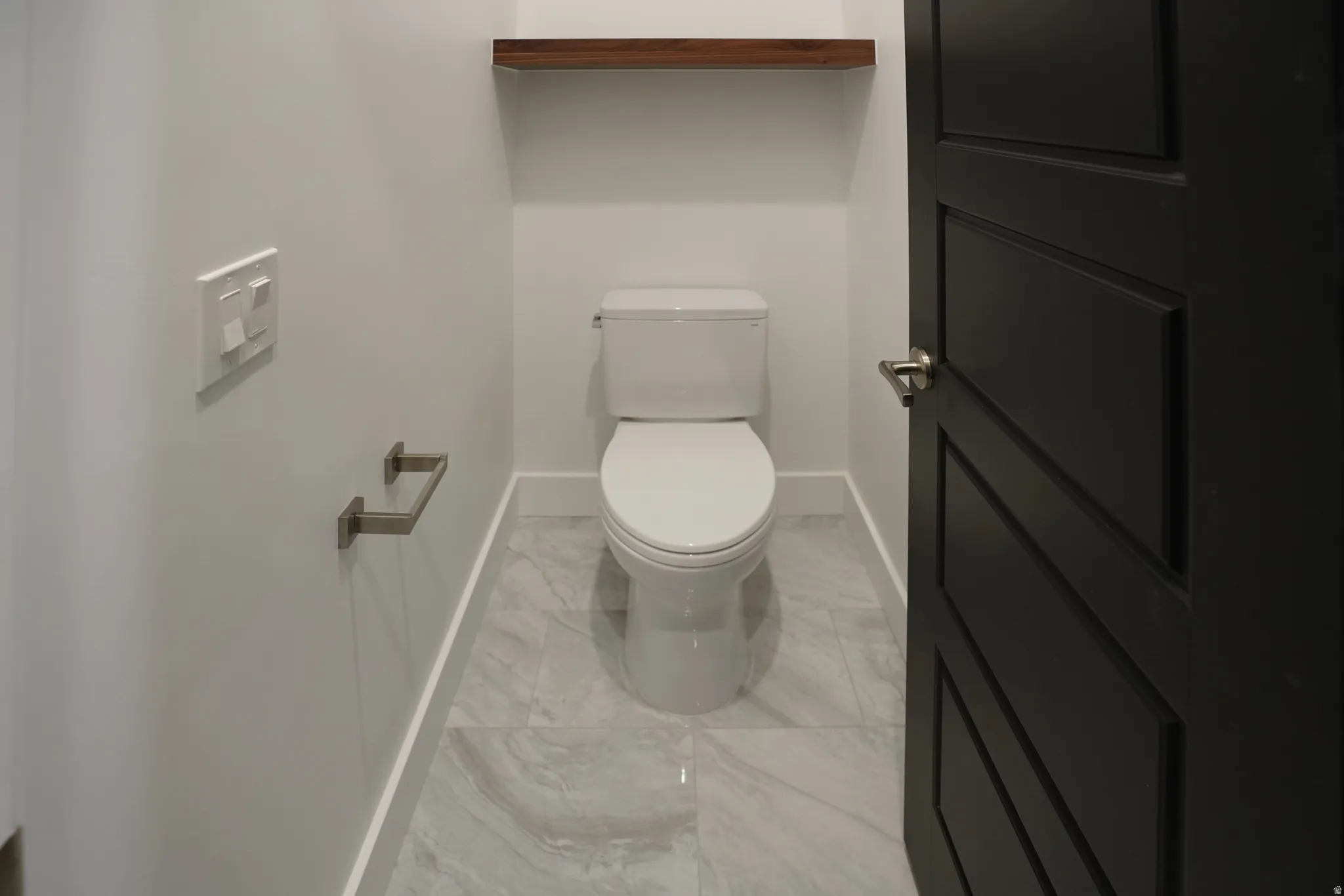 Bathroom with toilet and light marble finish flooring