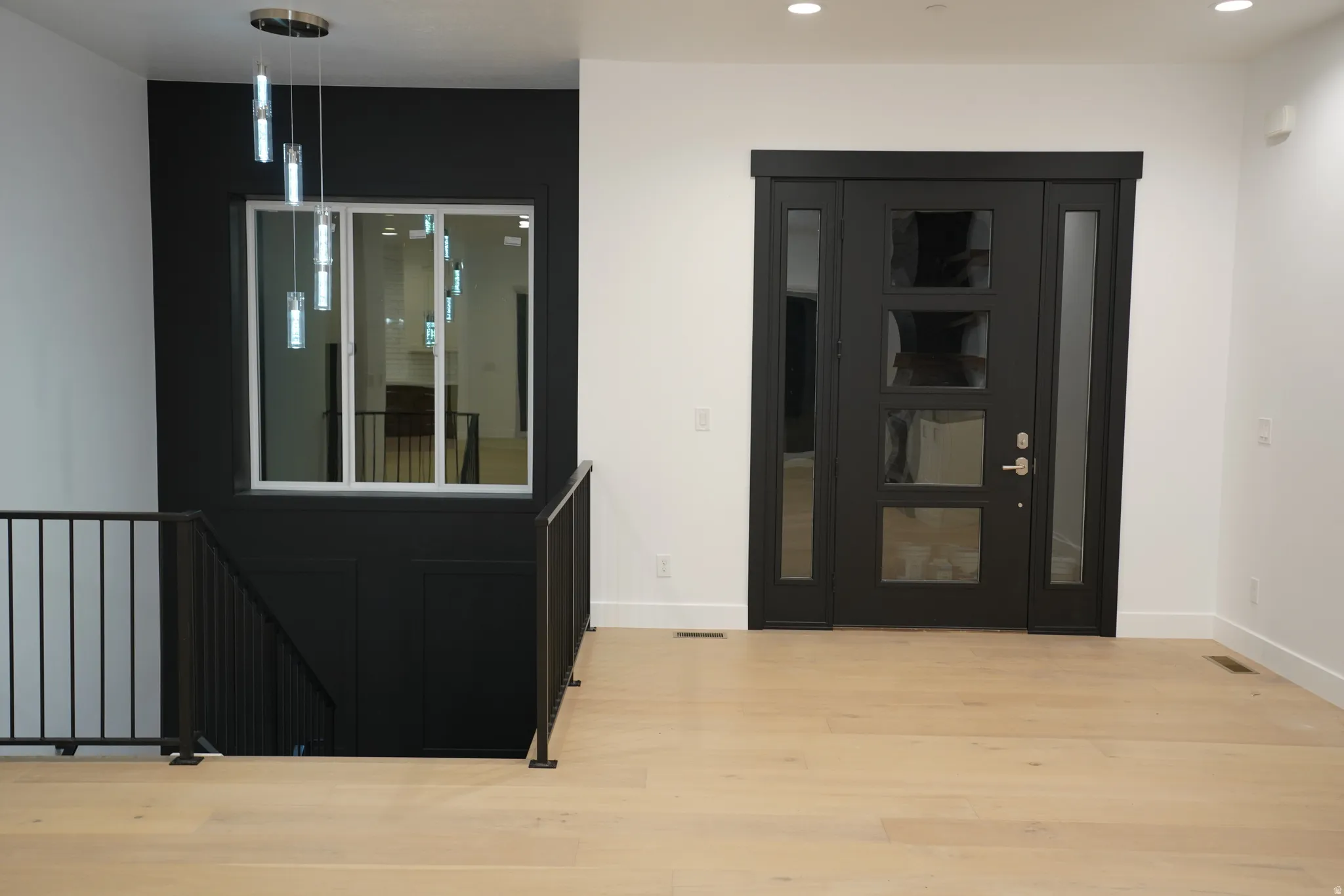 Foyer entrance with light wood finished floors and recessed lighting