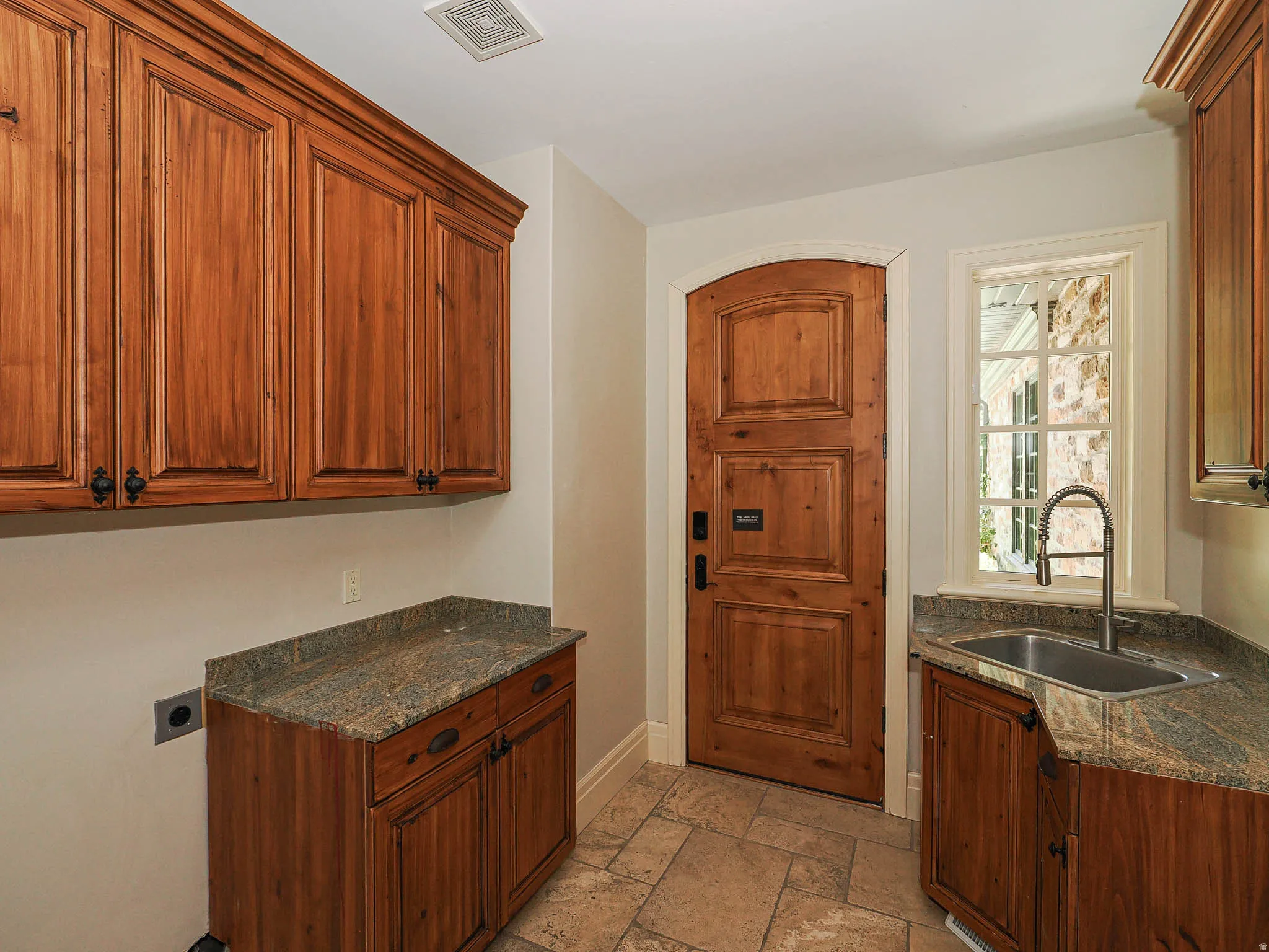 Laundry area with cabinet space, stone tile floors, and electric dryer hookup