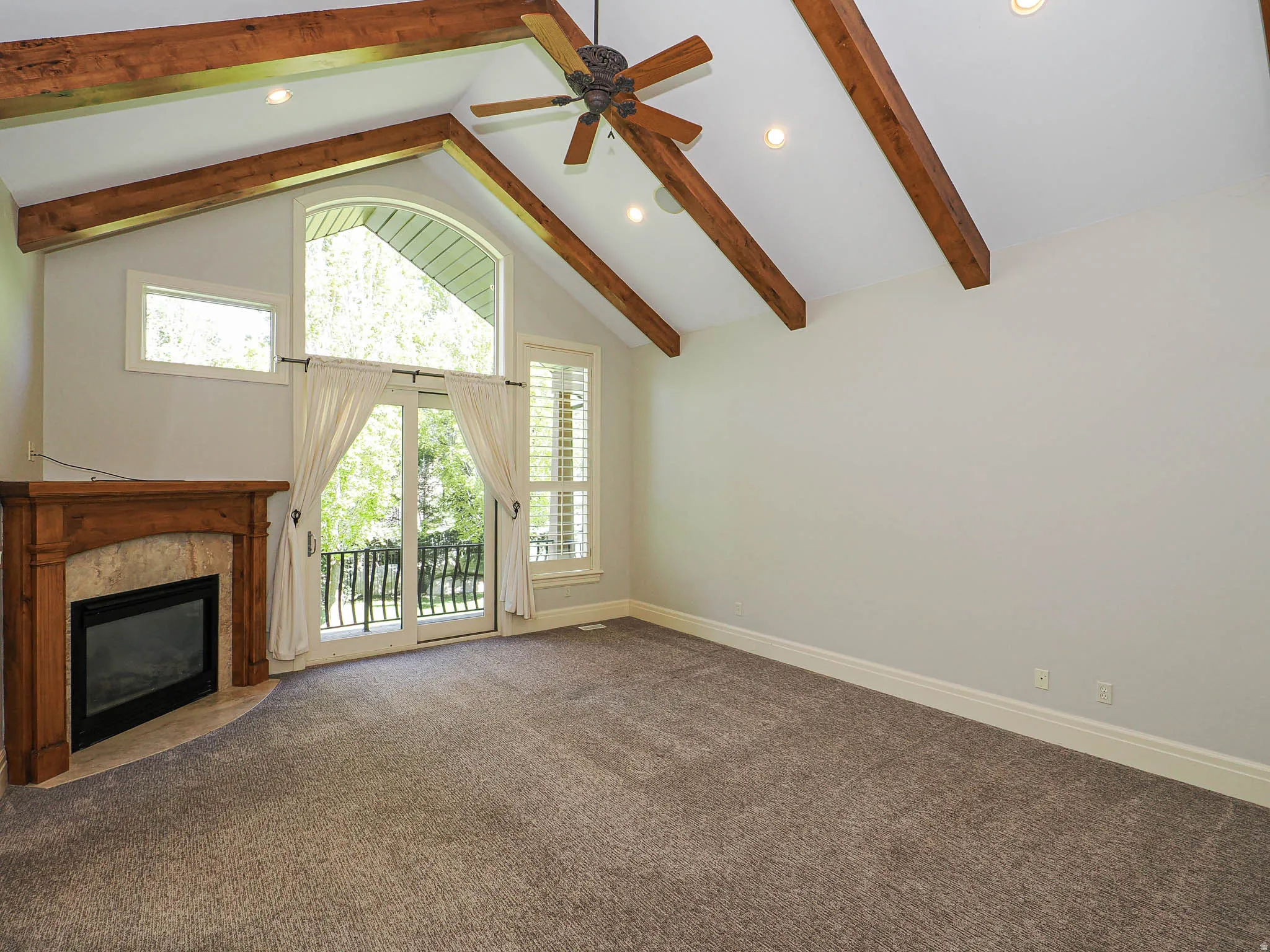 Unfurnished living room with dark colored carpet, a premium fireplace, ceiling fan, and recessed lighting