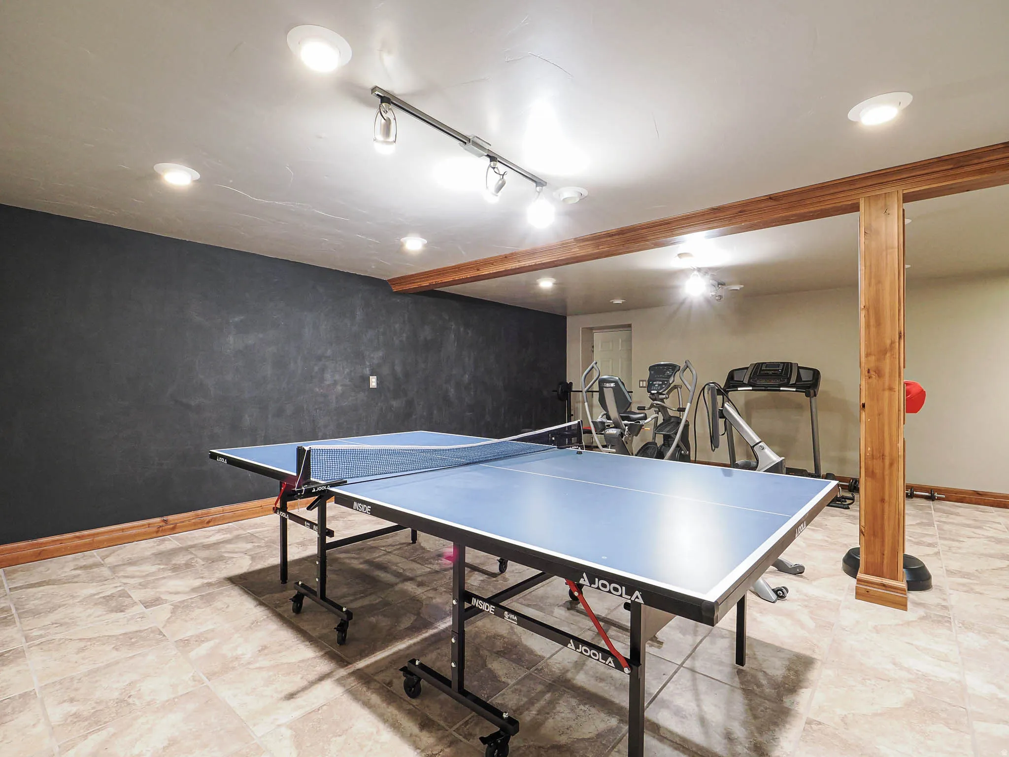 Game room featuring rail lighting and beam ceiling