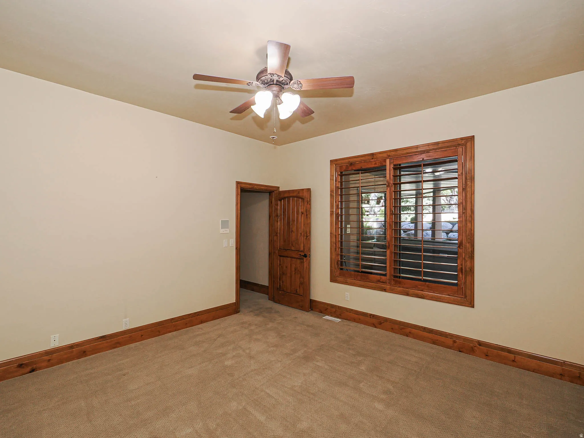 Carpeted empty room featuring baseboards and a ceiling fan