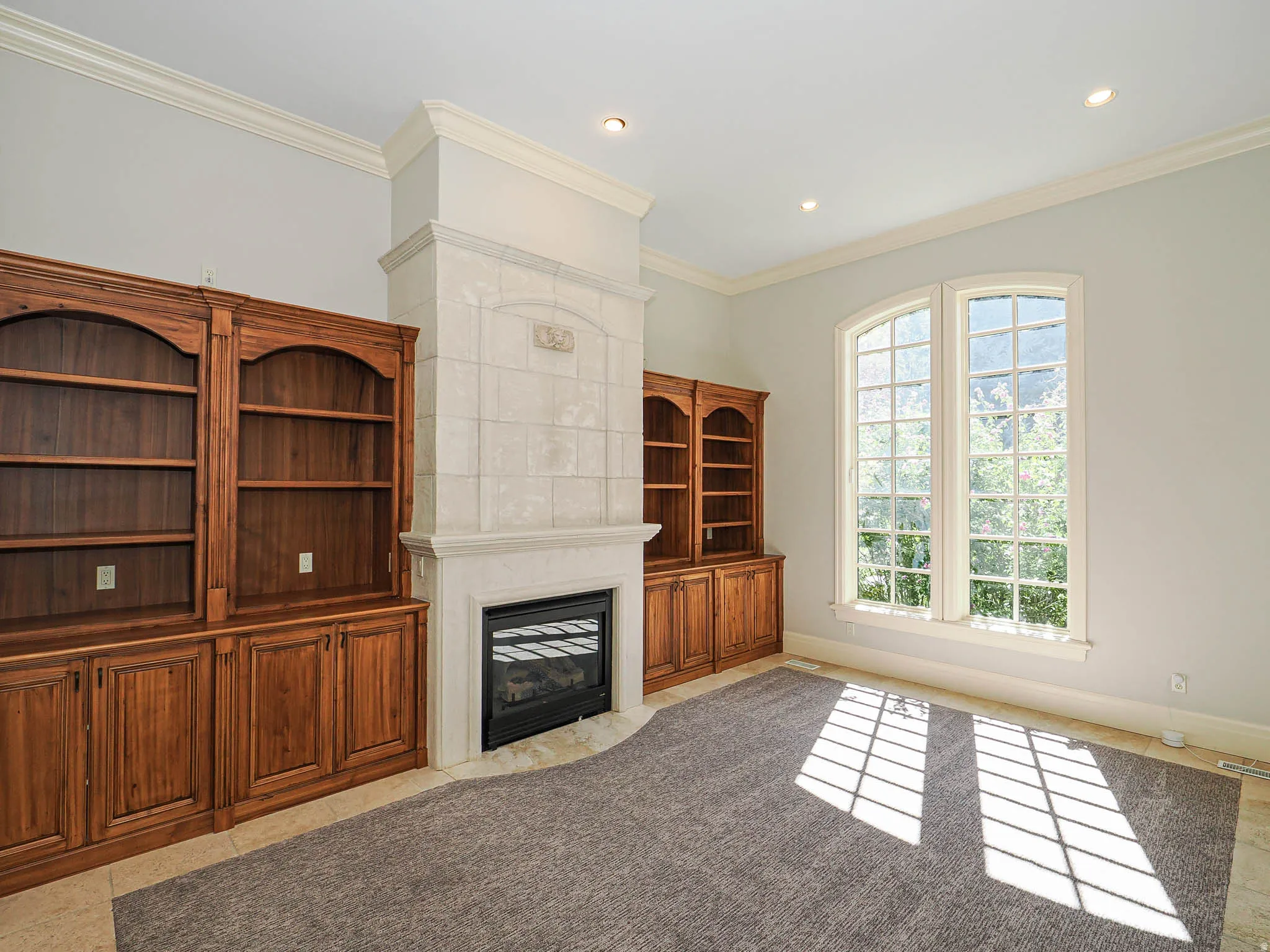 Unfurnished living room with ornamental molding, a fireplace with flush hearth, recessed lighting, and light tile patterned floors