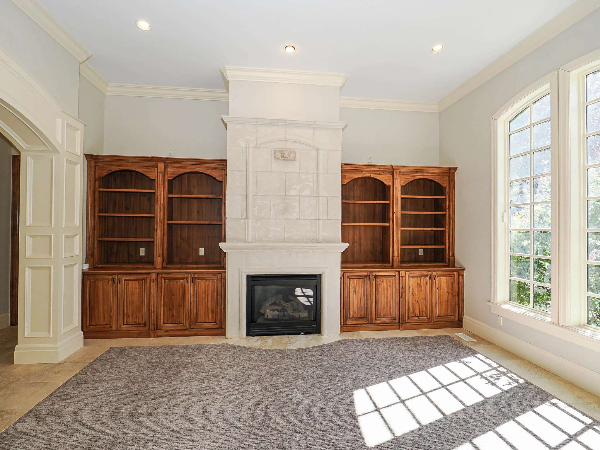 Unfurnished living room with crown molding, a large fireplace, and recessed lighting