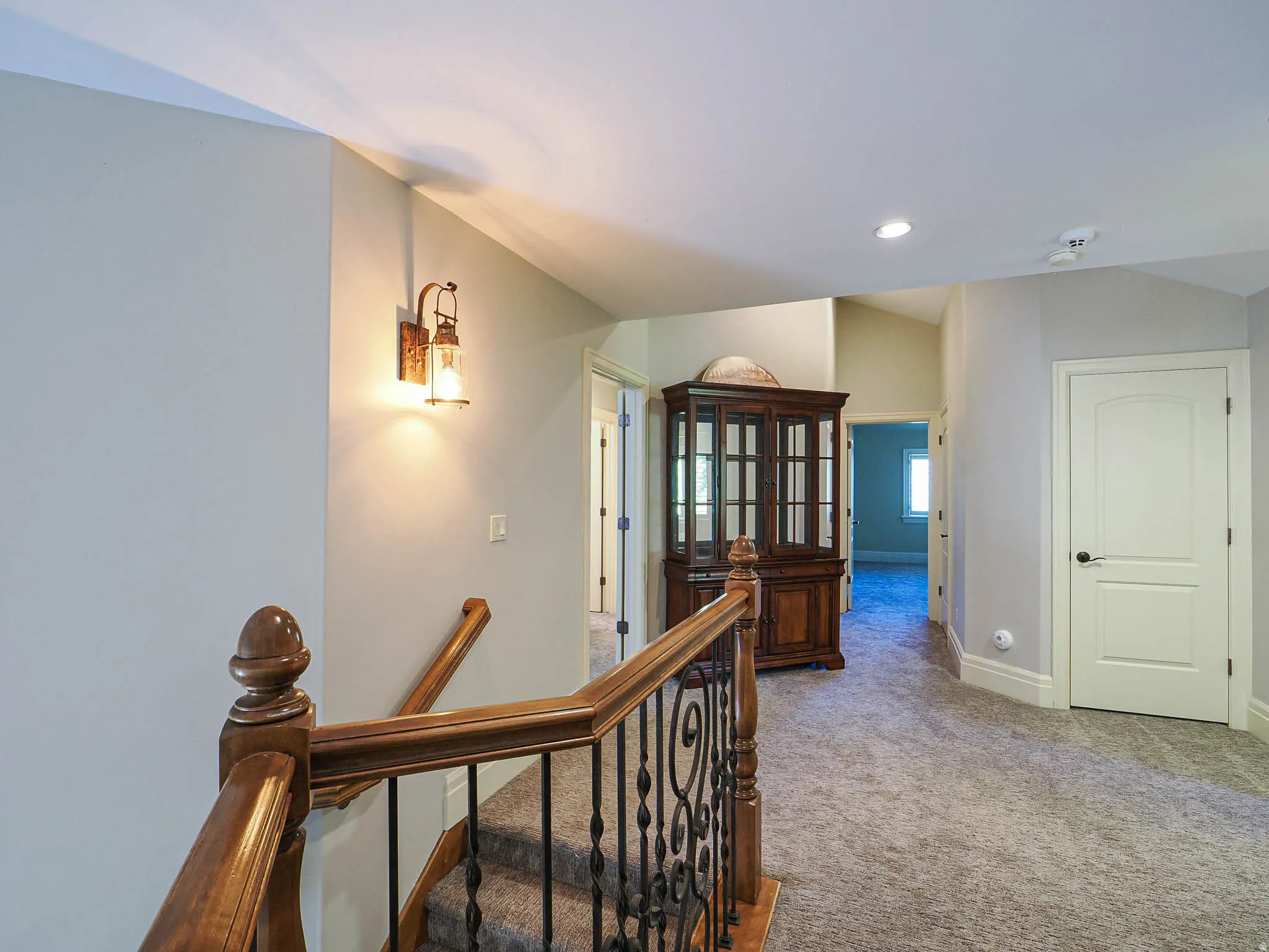Hallway featuring an upstairs landing, carpet flooring, and recessed lighting