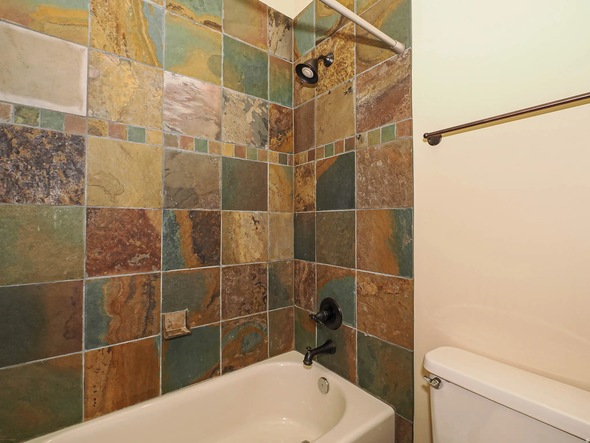 Full bath featuring toilet and washtub / shower combination