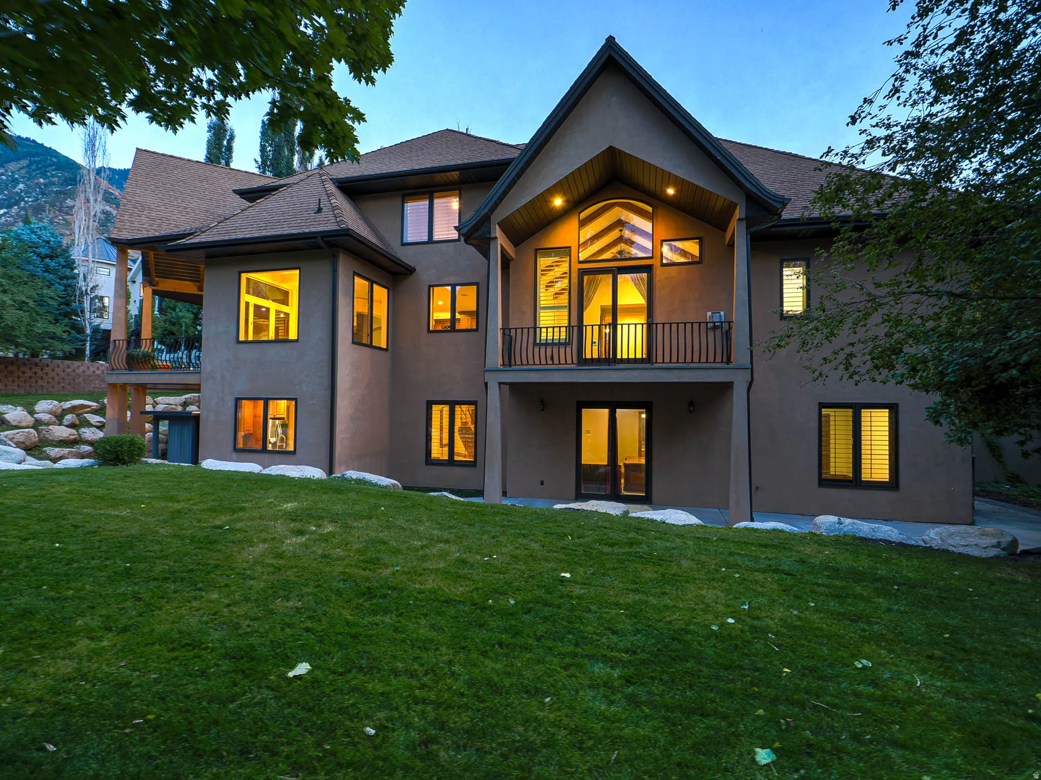 Rear view of house with a patio, a balcony, and a yard