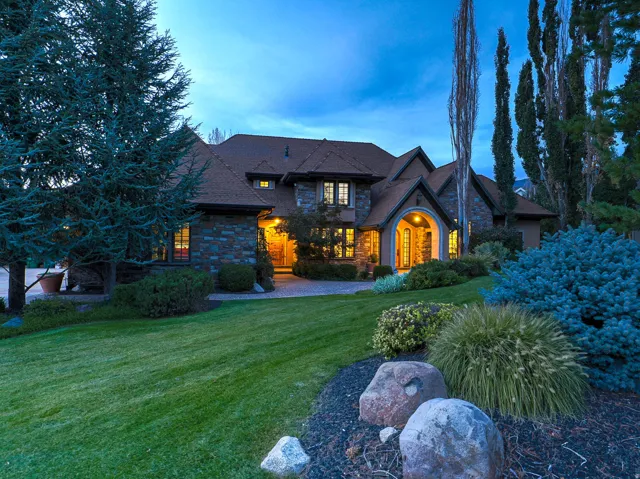 View of front of house featuring a lawn and stone siding