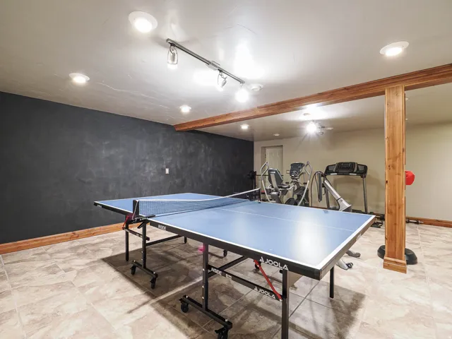 Game room featuring rail lighting and beam ceiling