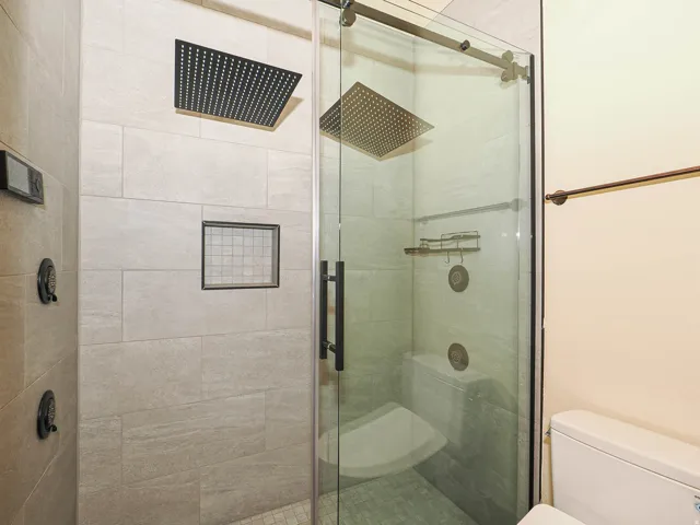 Bathroom featuring toilet and a stall shower