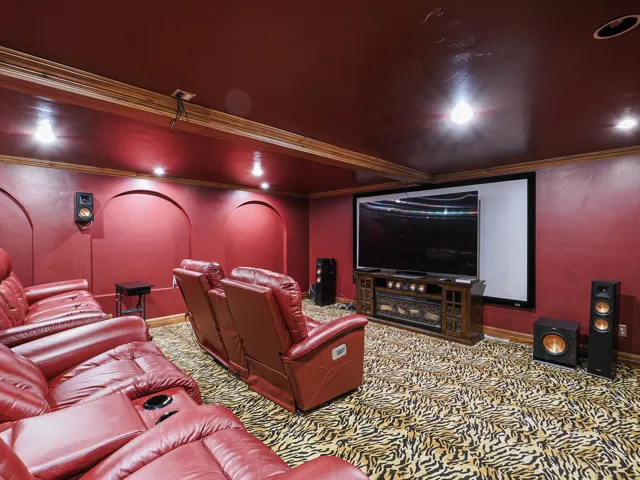 Home theater with ornamental molding and carpet