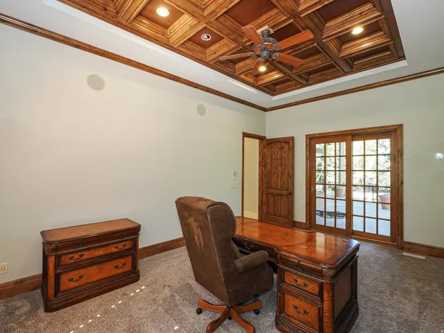 Carpeted home office featuring crown molding, coffered ceiling, a ceiling fan, recessed lighting, and wood ceiling
