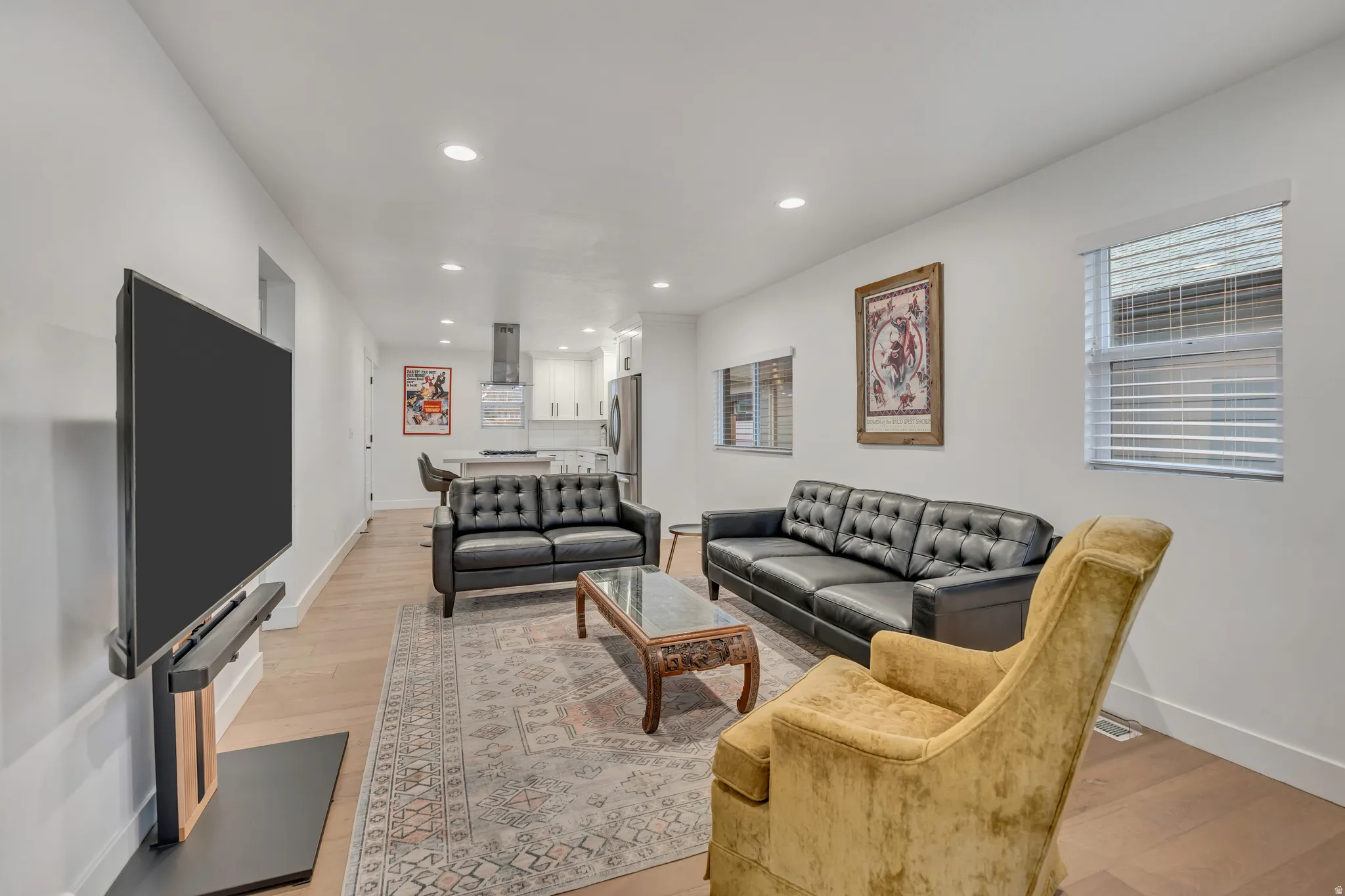 Living area with light wood-style flooring and recessed lighting