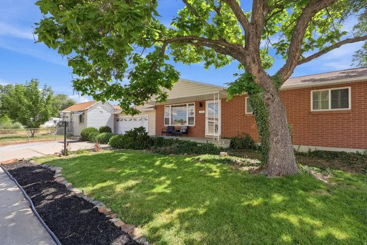 Brick exterior home featuring a covered front porch and an attached garage