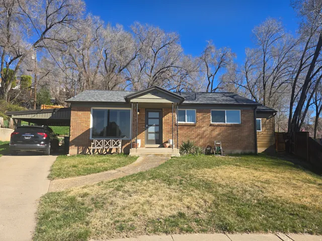 View of front of property with brick siding, an attached carport, and concrete driveway
