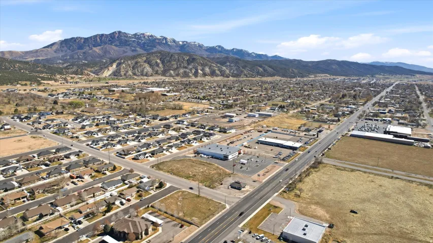 Aerial view of property's location featuring a mountain backdrop and nearby suburban area
