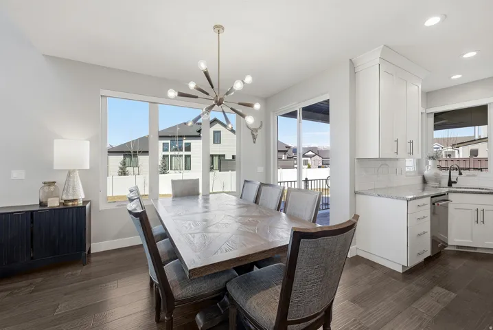 Dining area featuring wood-finish flooring, a contemporary sputnik chandelier, and expansive windows