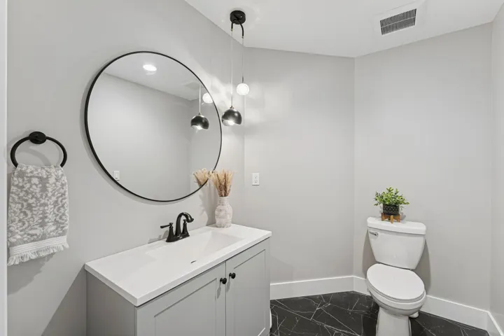Half bathroom featuring vanity and dark marble finish floors