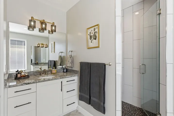 Bathroom featuring vanity and a shower stall