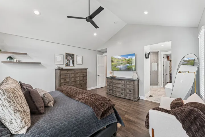 Bedroom with dark wood-style flooring, a ceiling fan, recessed lighting, and ensuite bath