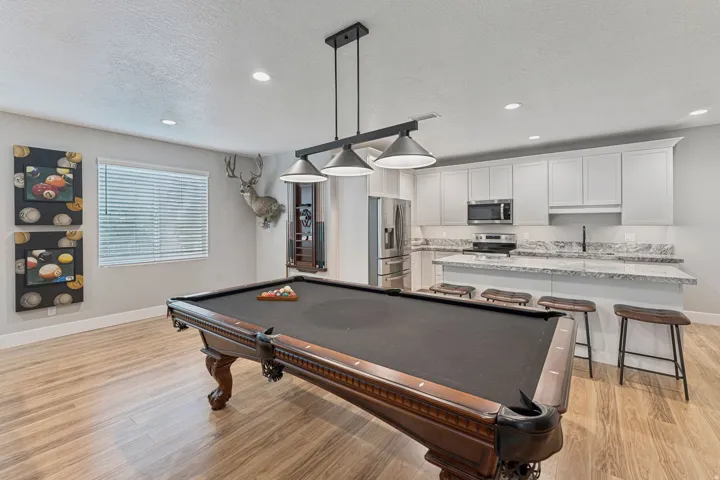 Recreation room with billiards, a textured ceiling, light wood-type flooring, and recessed lighting