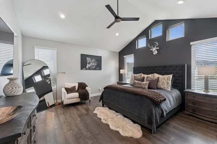 Bedroom featuring a high ceiling, dark wood-style floors, ceiling fan, and recessed lighting