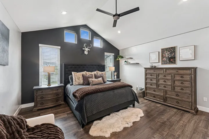 Bedroom featuring multiple windows, dark wood-style floors, a ceiling fan, a high ceiling, and recessed lighting