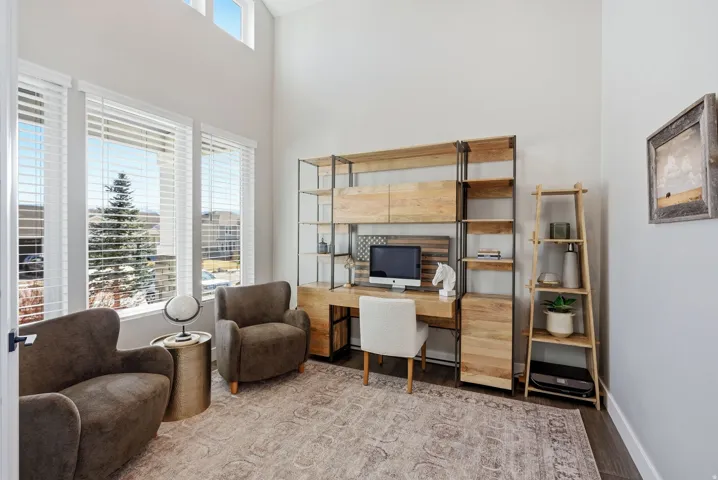 Office space featuring wood finished floors and a high ceiling